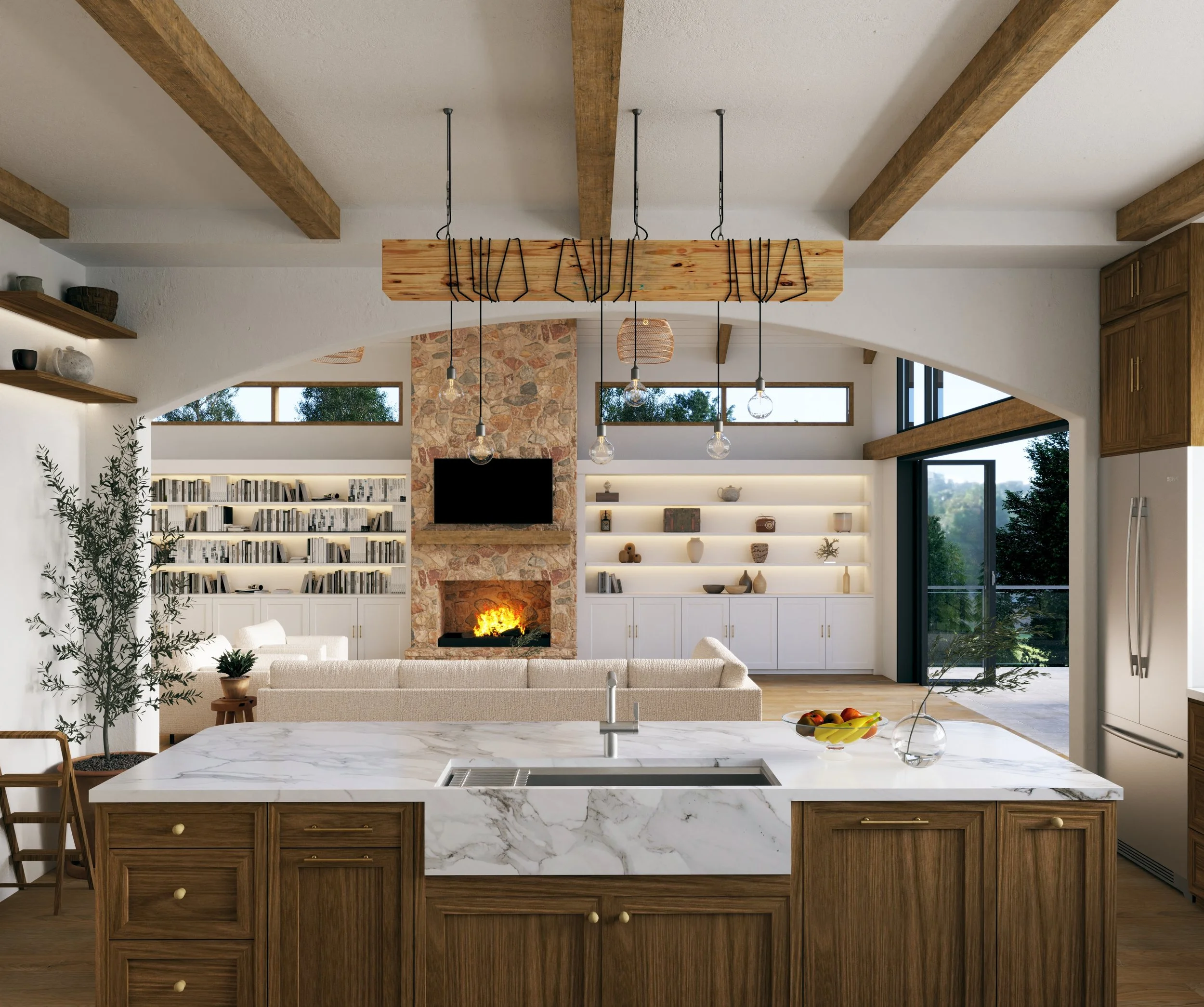 Open-concept living room and kitchen with a marble island, wooden cabinets, and a large stone fireplace with a fire. Shelves with books and decorative items are on the walls, and there are windows and doors letting in natural light.