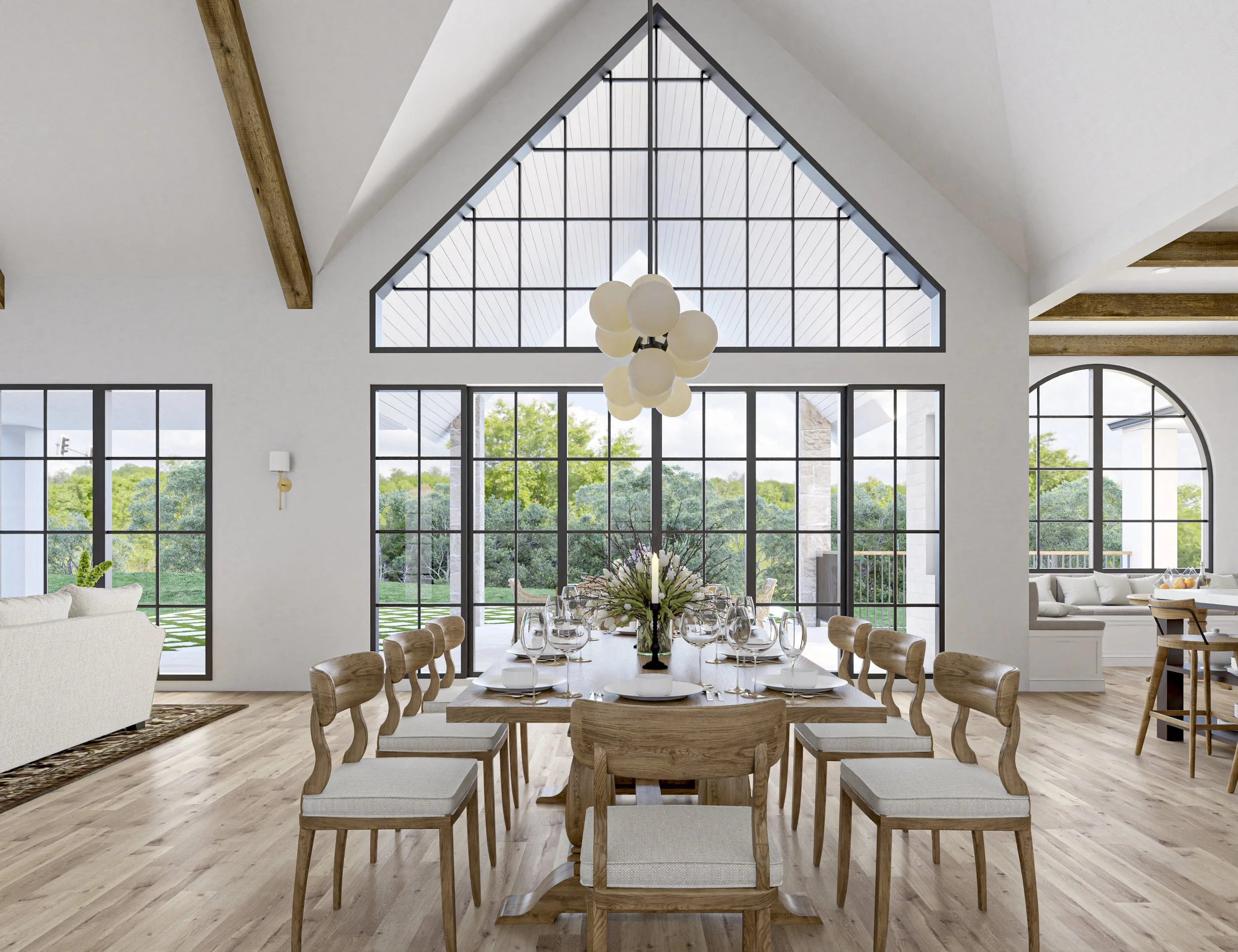 Bright dining room with large windows, wooden table set for a meal, surrounded by wooden chairs, with a view of greenery outside.