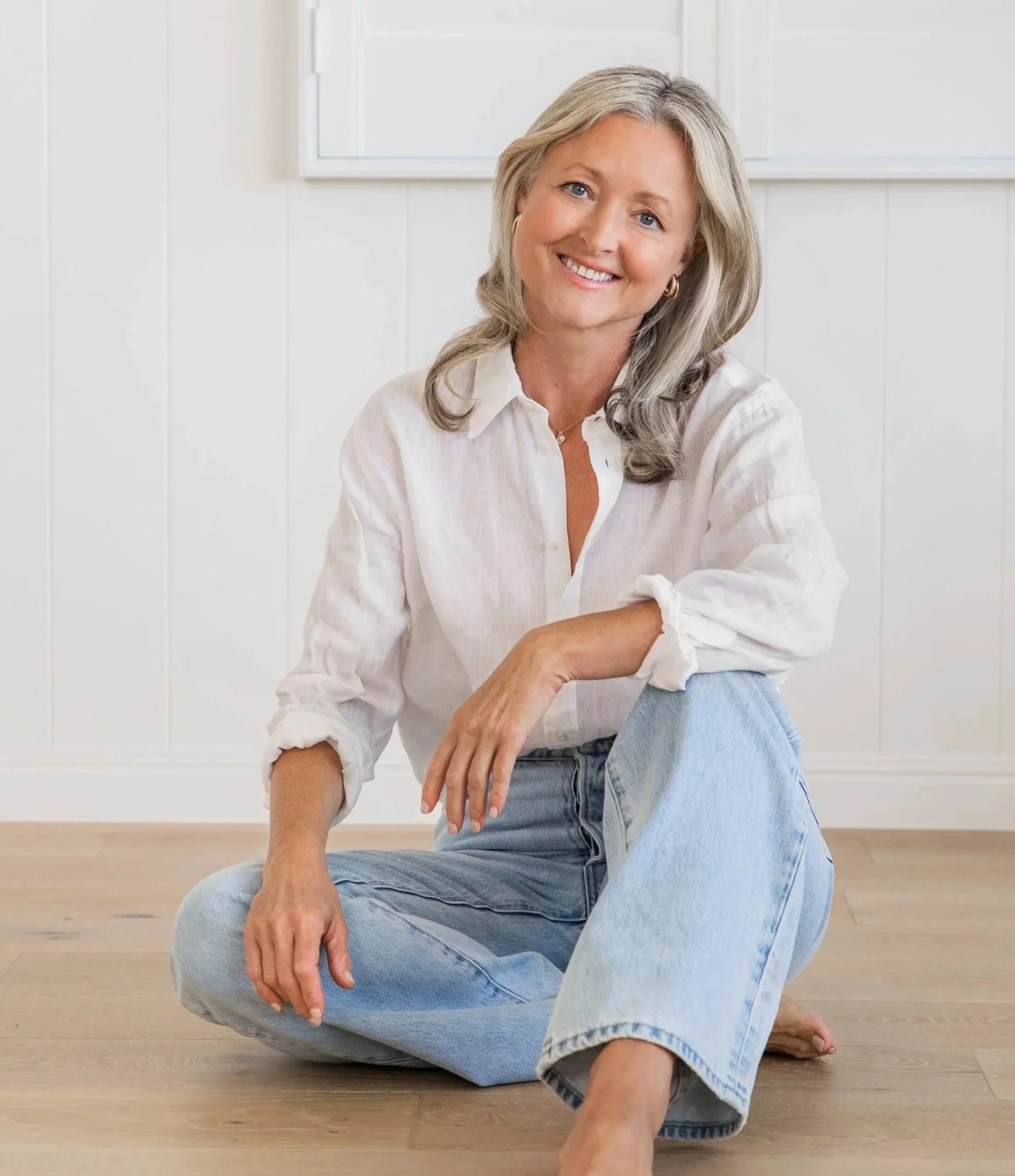 Anna Hutchins, founder of Ageless Nutrition, sitting cross-legged by a window