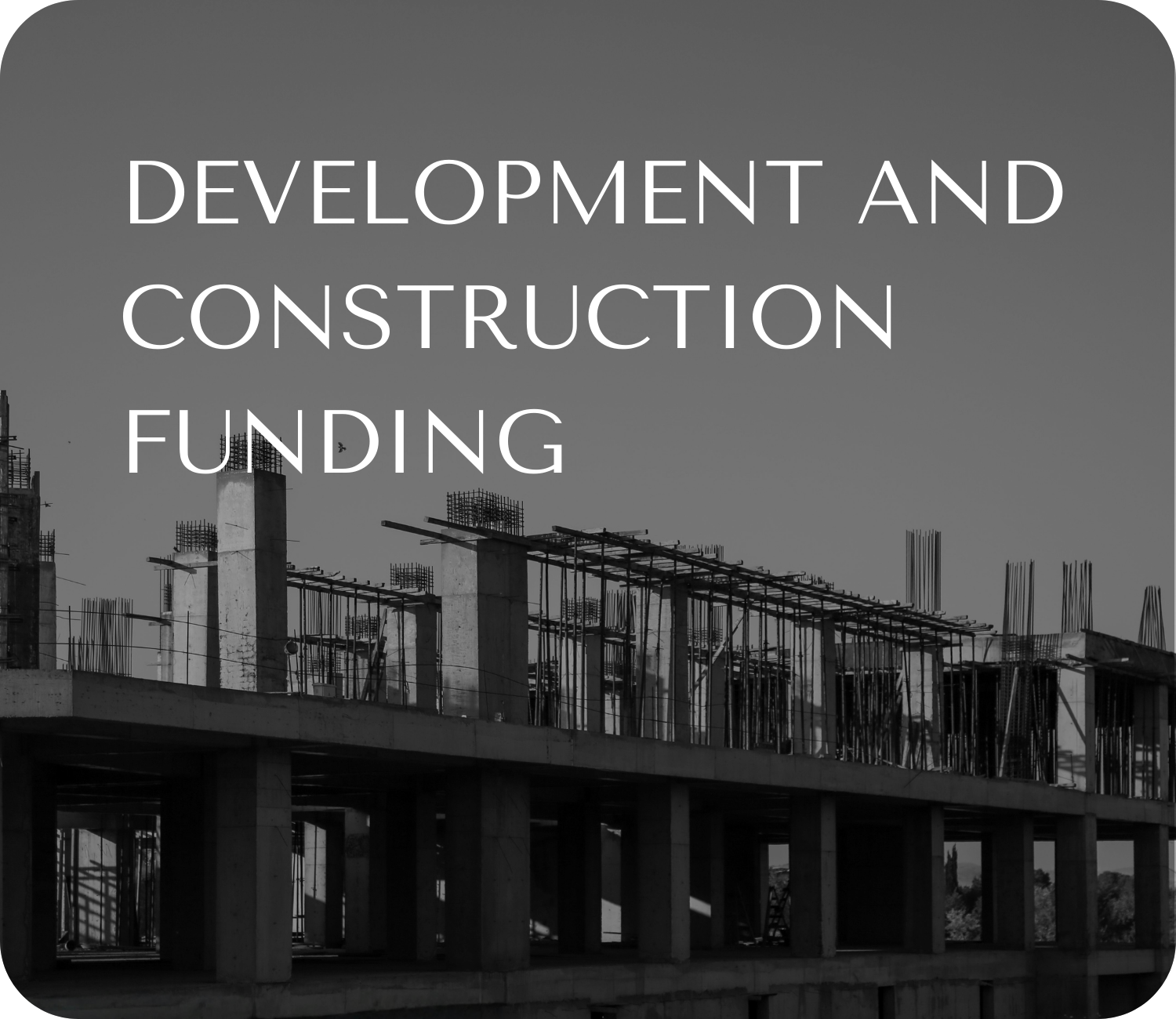 Black and white photo of a building under construction with visible concrete columns and steel reinforcement bars.