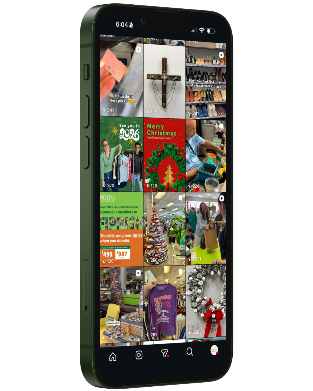 Smartphone screen displaying a grid of Christmas and thrift store shopping videos and images, including holiday decorations, clothing, and store scenes.
