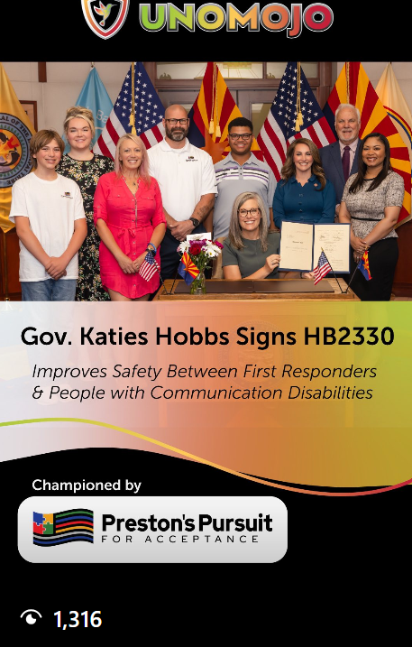 Group of eight people, including Gov. Kathy Hobbs, standing behind a woman seated at desk with a signed document, surrounded by American flags and flags of other states. The image promotes HB2330 for safety between first responders and people with communication disabilities.