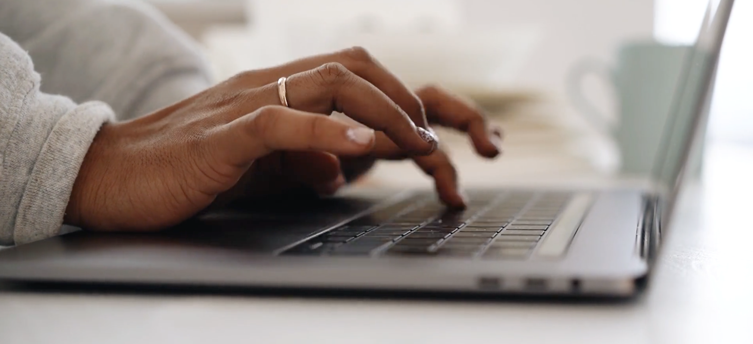Rooted Collective Woman Typing on Laptop Computer.png