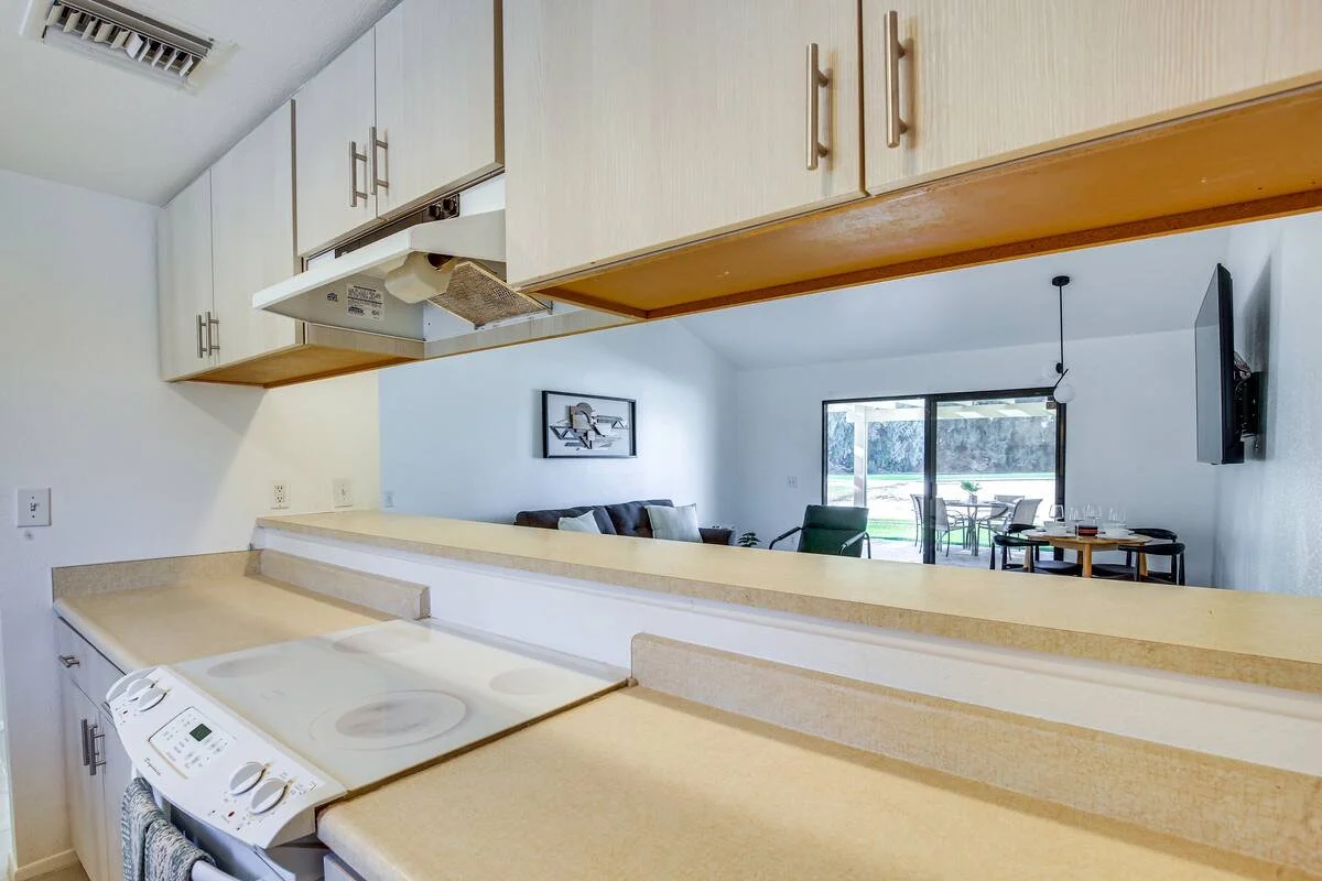 View from kitchen looking into living room with sliding glass door in the background.
