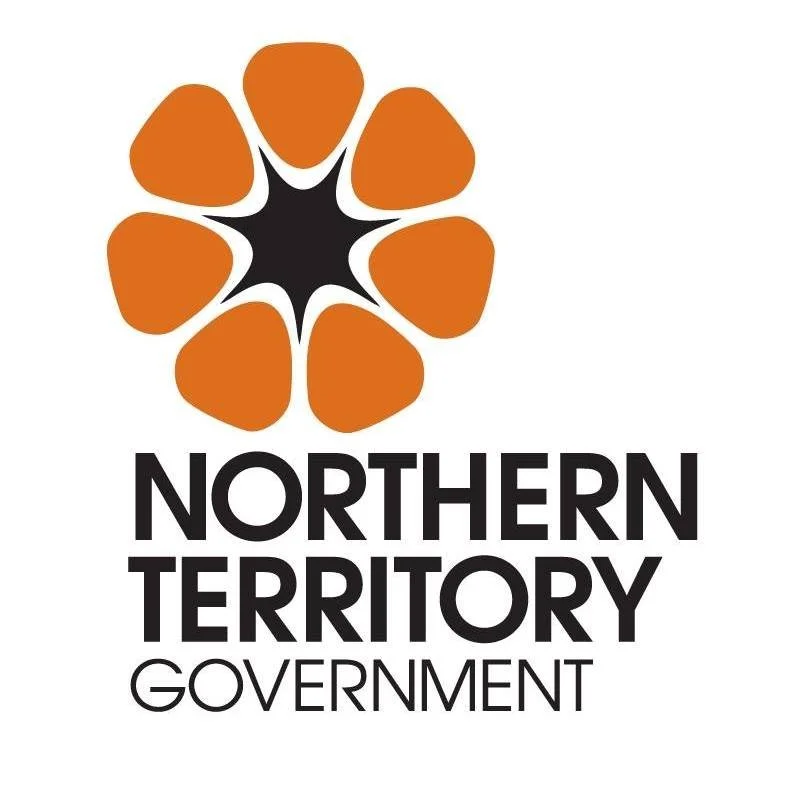 Logo for Northern Territory Government featuring a stylized orange flower with black and white details above the text 'Northern Territory Government' in black.