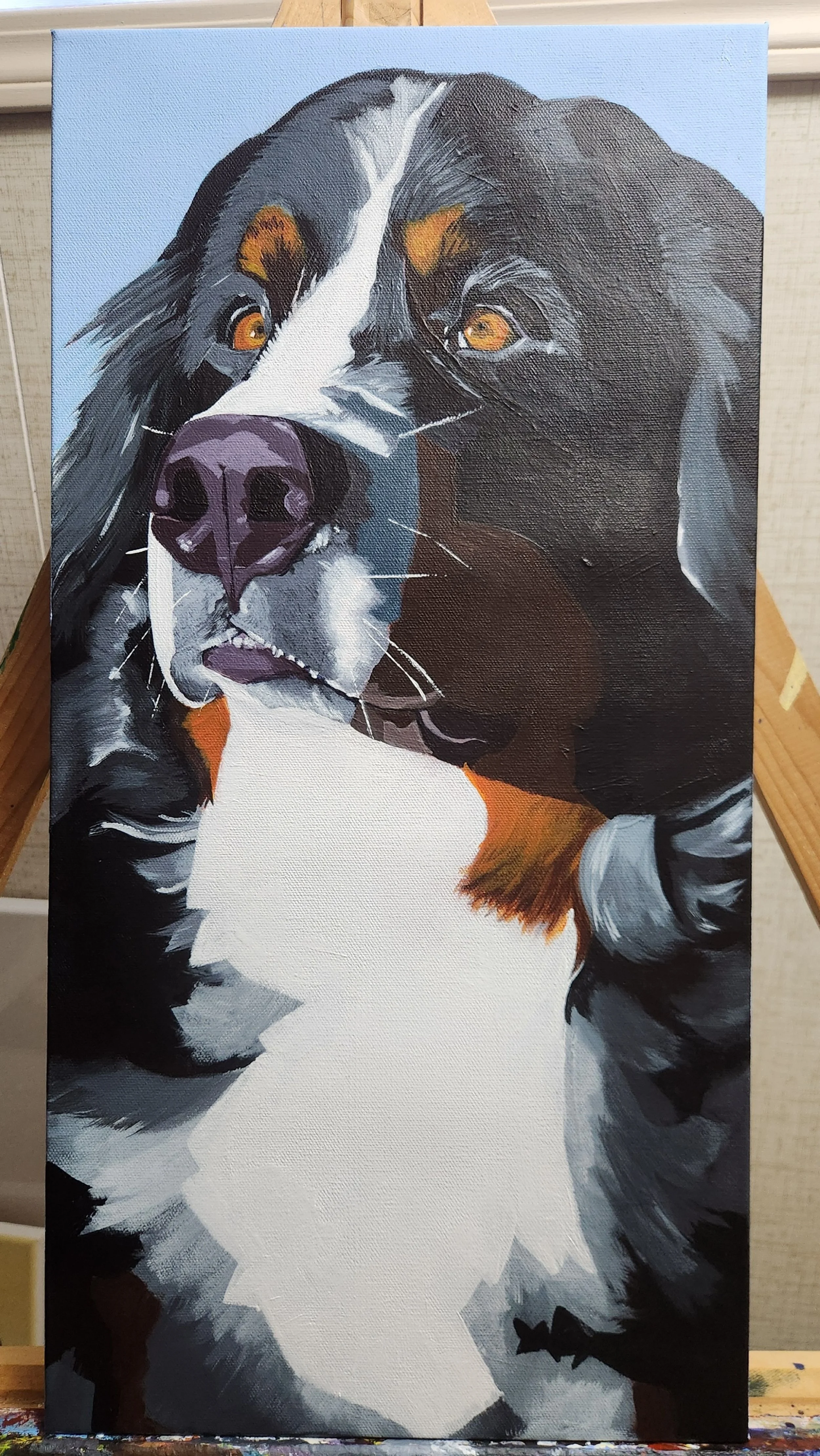 Painting of a black and white dog with brown eyes, possibly a Border Collie, on a canvas.
