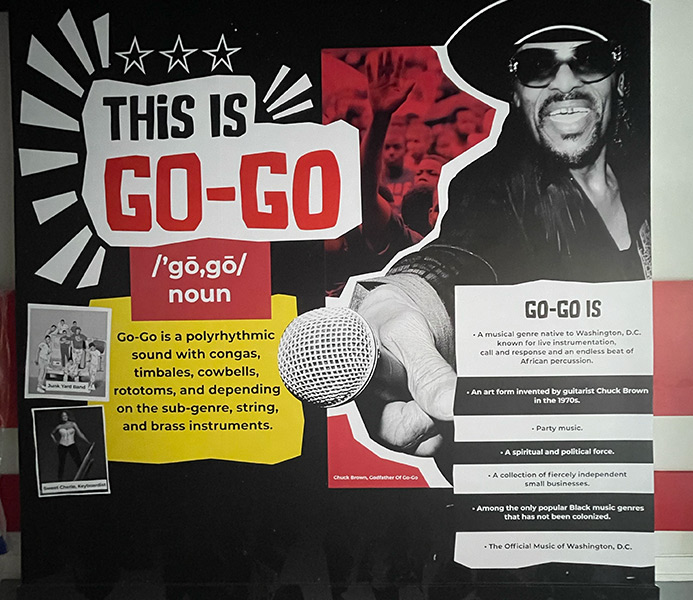 Image Graphic of Chuck Brown holding out a microphone across a sign that says: This is Go-Go