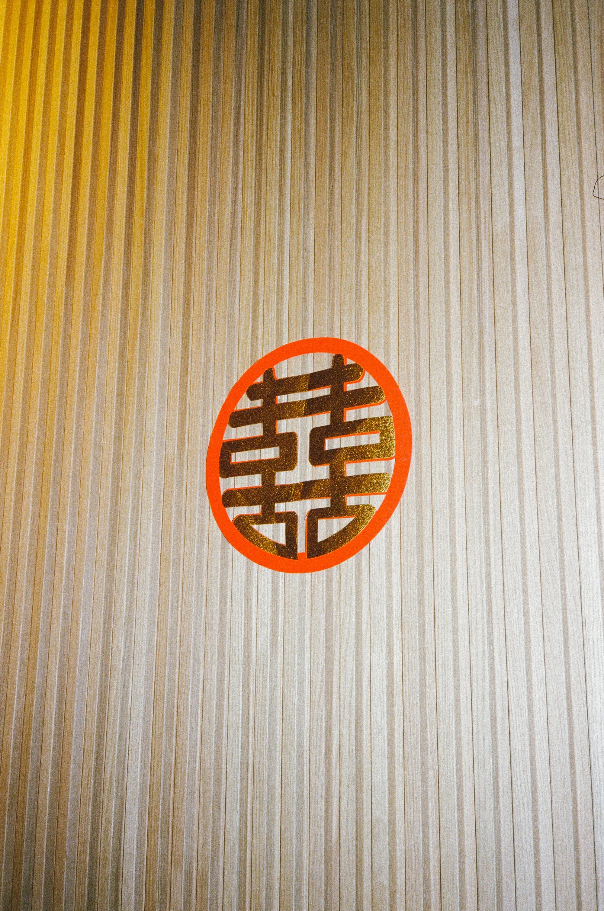 Decorative Japanese paper with a gold Chinese character in an orange circle.