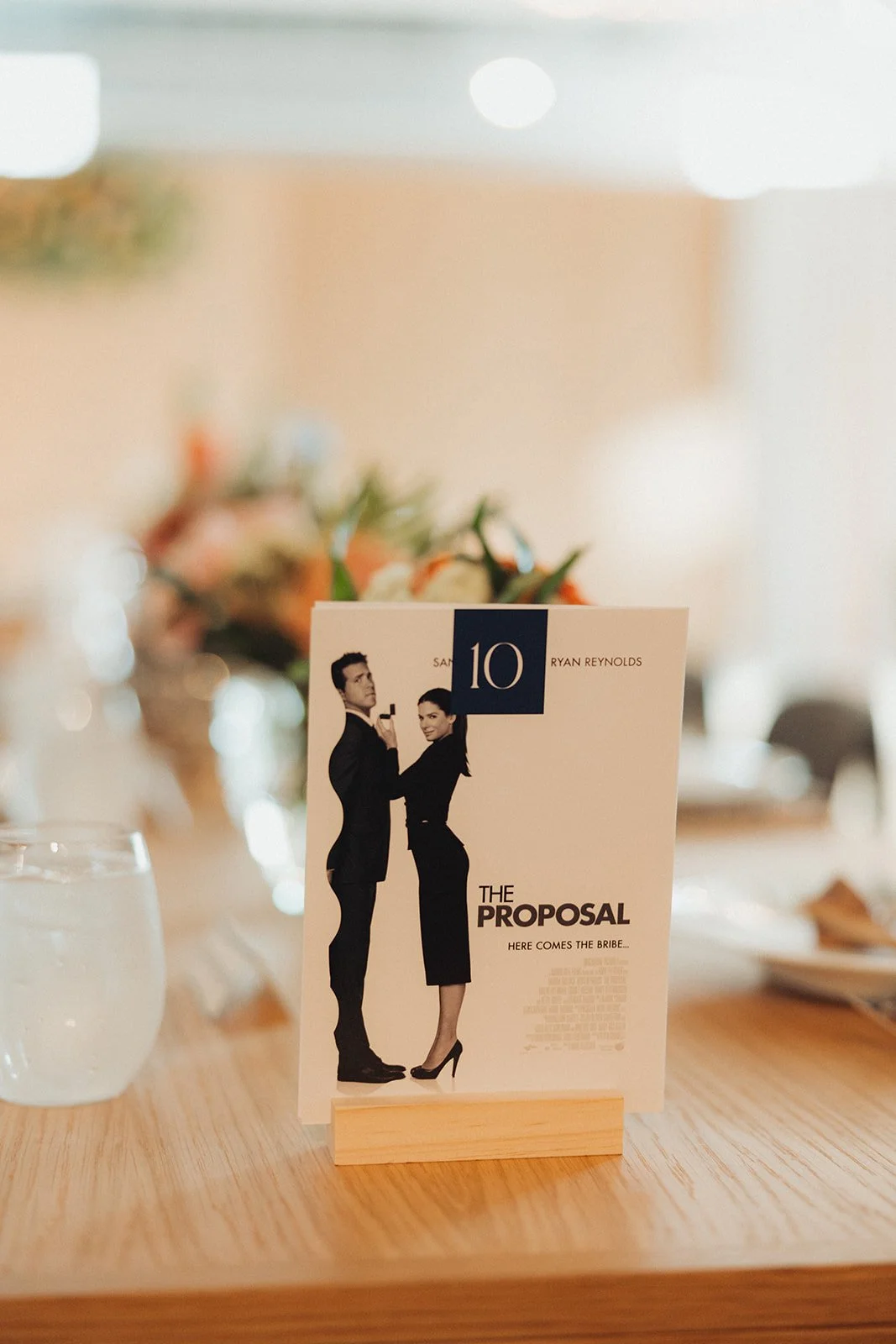 Menu card for the movie 'The Proposal' with the tagline 'Here Comes the Bribe' and a picture of a man and woman in formal business attire standing close together.