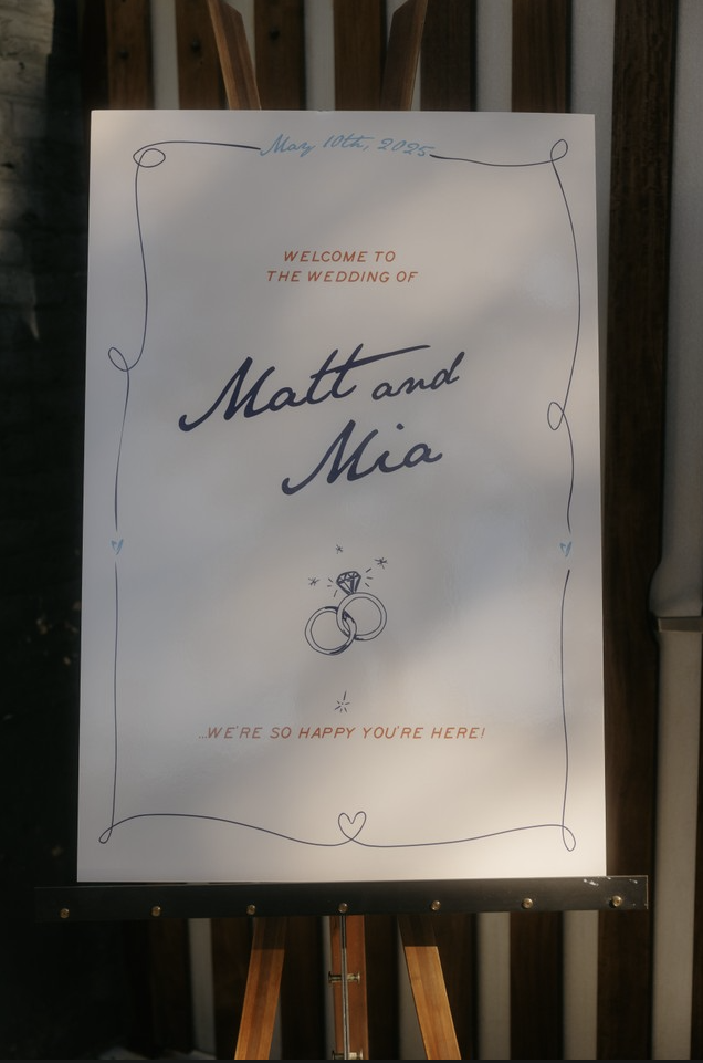 Wedding welcome sign with the names Matt and Mia, dated May 10th, 2025, featuring wedding rings and a diamond ring illustration, decorated with a simple border and hearts.