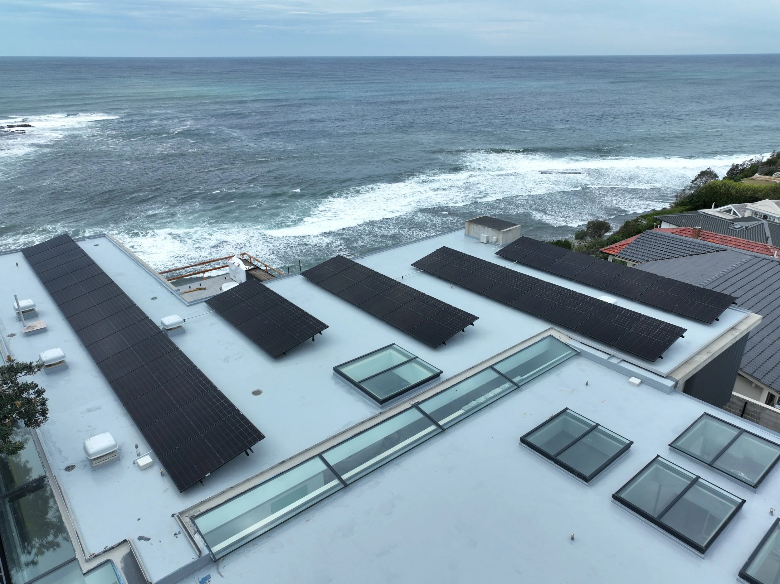 Roof with multiple black solar panels installed by Kennedys in Sydney