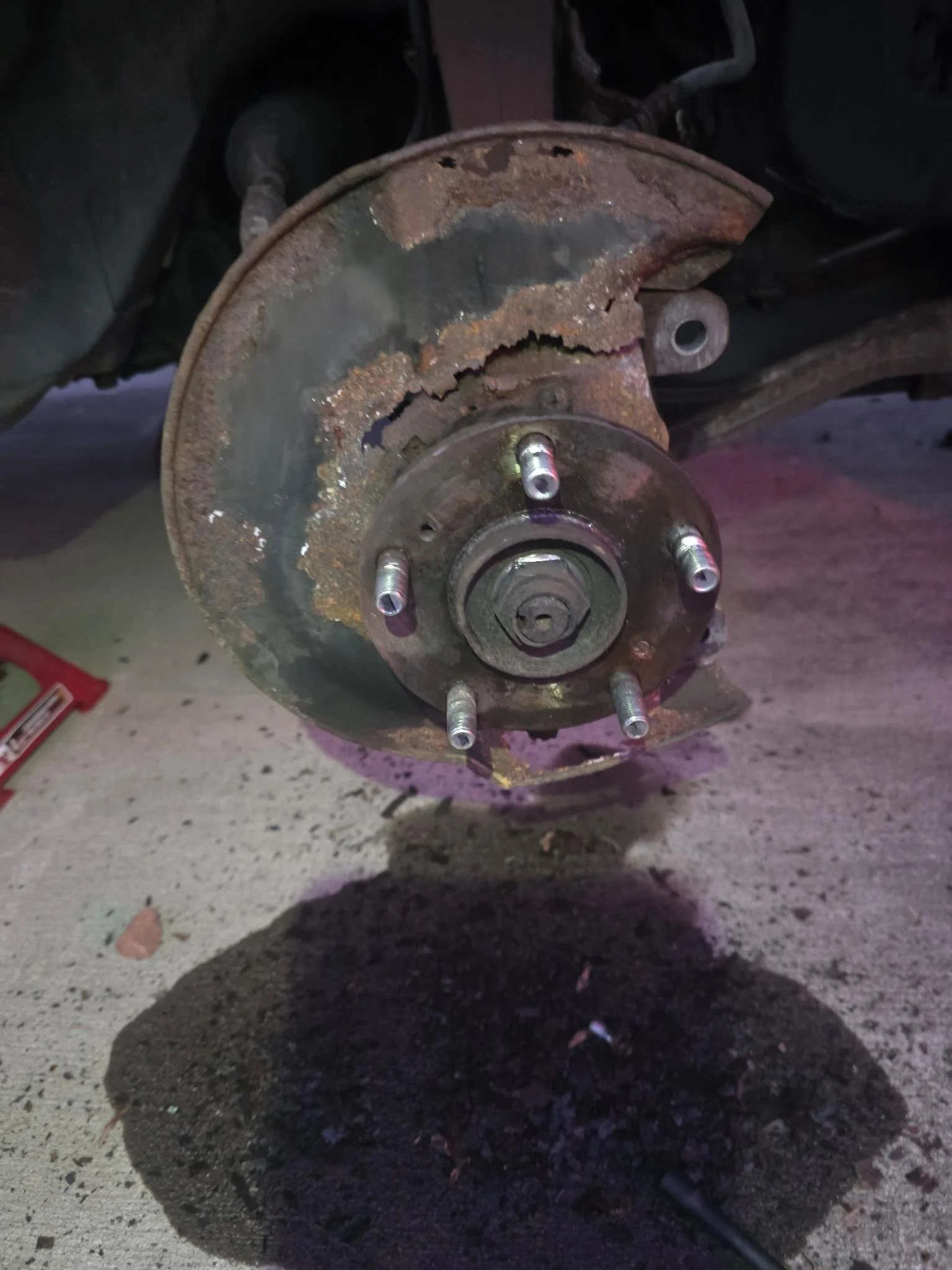 A 2007 Honda Accord wheel hub with rust, missing the wheel, showing the brake drum and wheel studs.  Showing the state of the car before the team started work.