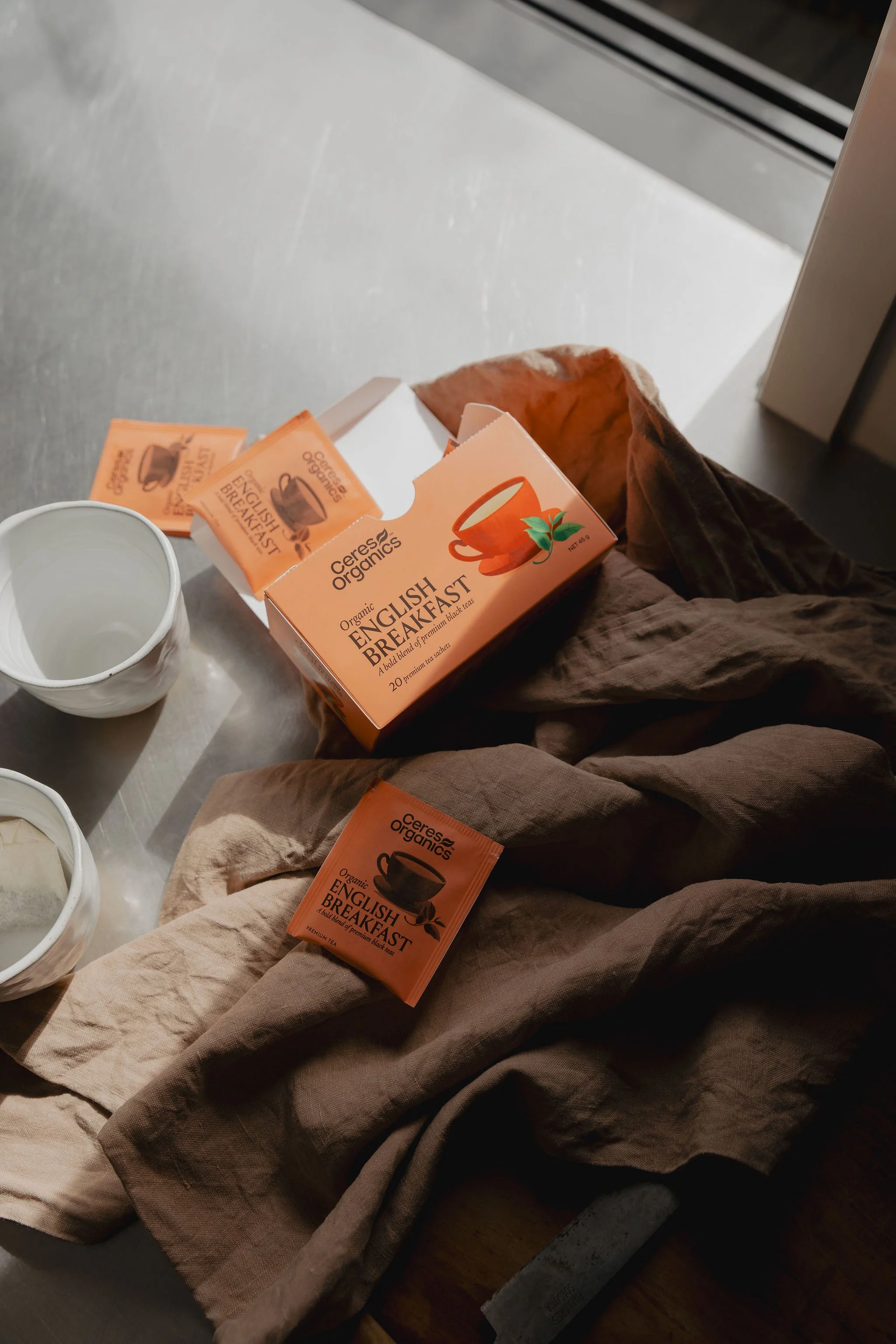 A box of Ceres Organics English Breakfast tea and a white ceramic cup.