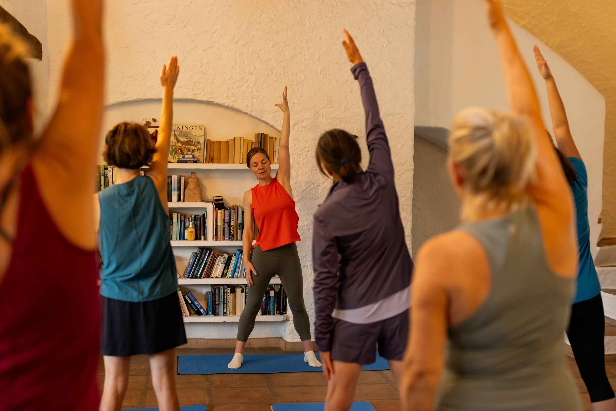 Jenny leading a small Pilates class at Core Pilates Oban with clients practising standing side stretches.