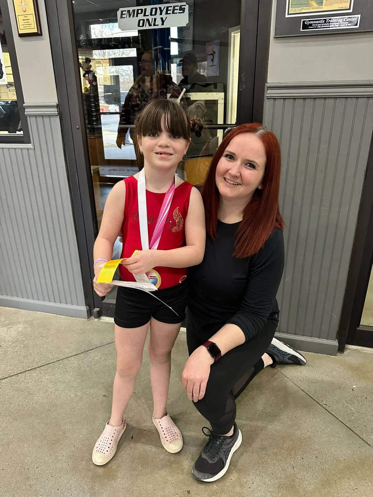 gymnast with coach with a medal