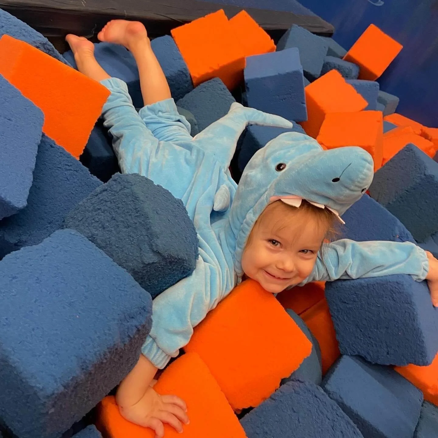 child in a shark suit in a block pit