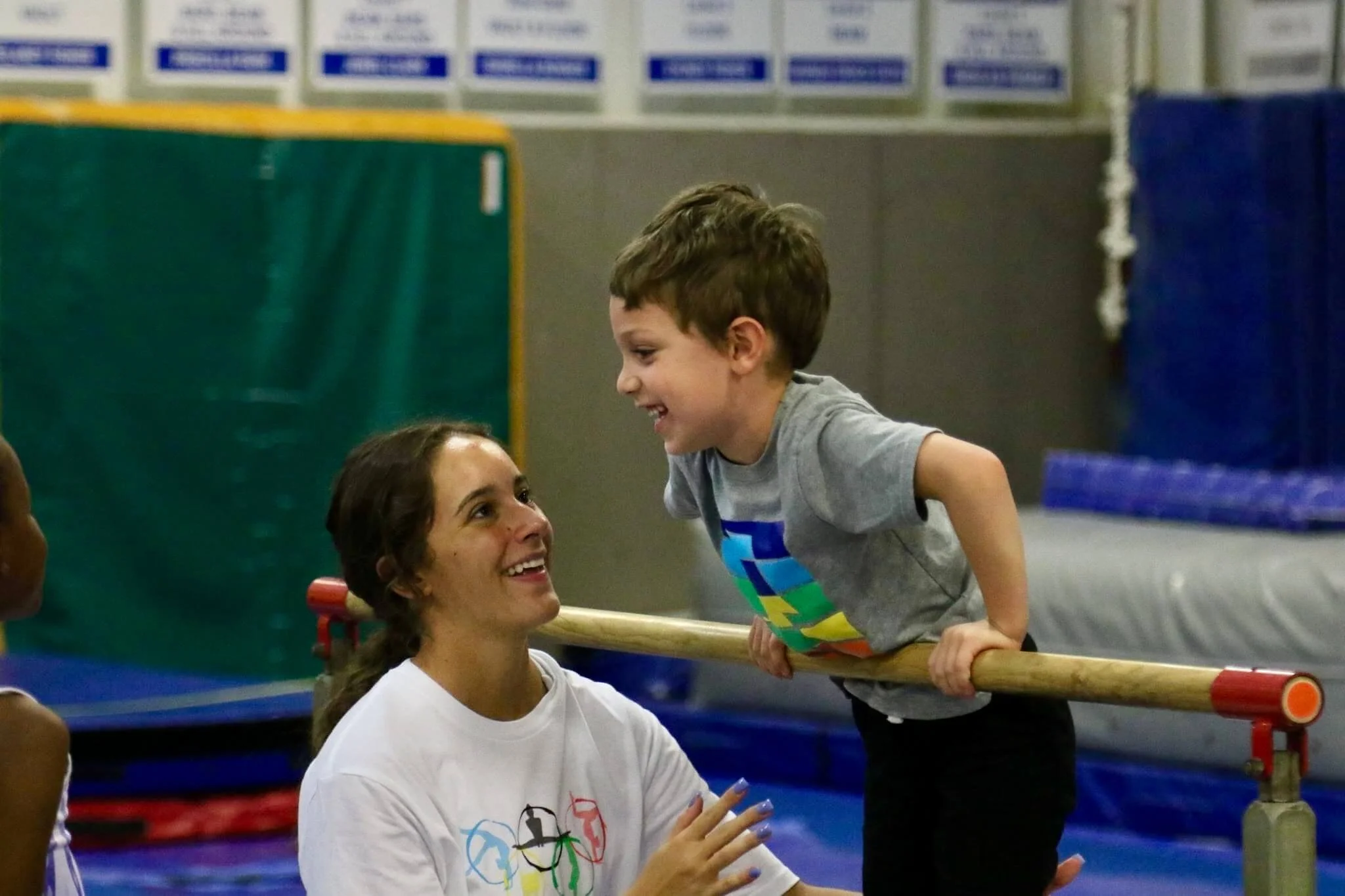 boy gymnast on bar with coach