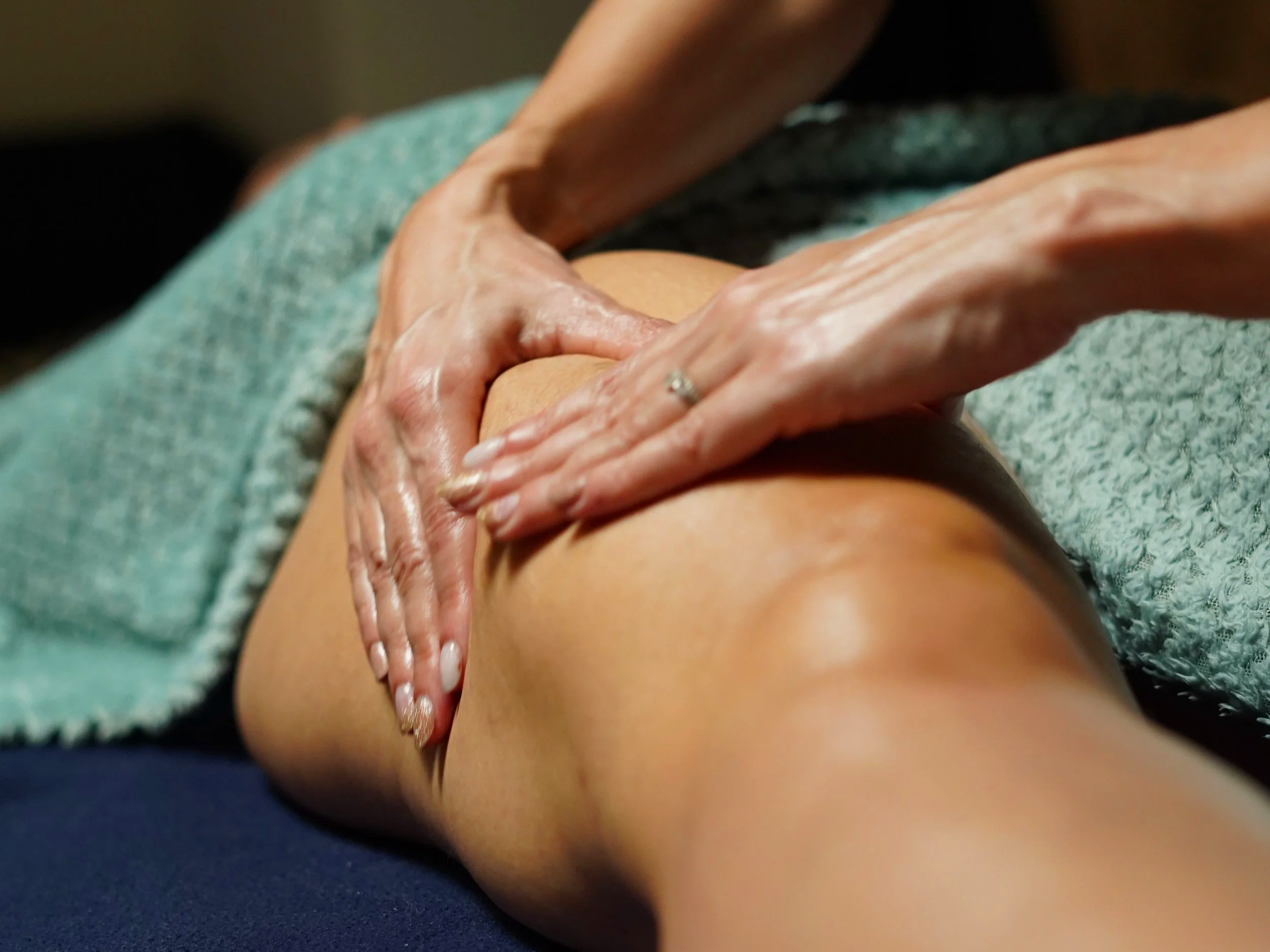 Une personne reçoit un massage sur le dos, la main du masseur est visible.