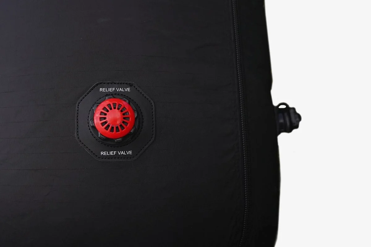 Valvola di rilascio rossa su una valigia nera.