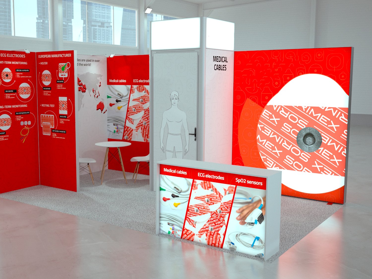 Stand espositivo con pannelli rossi che presentano cavi medici, elettrodi ECG e sensori SpO2, in un ambiente con grandi finestre e pareti bianche.