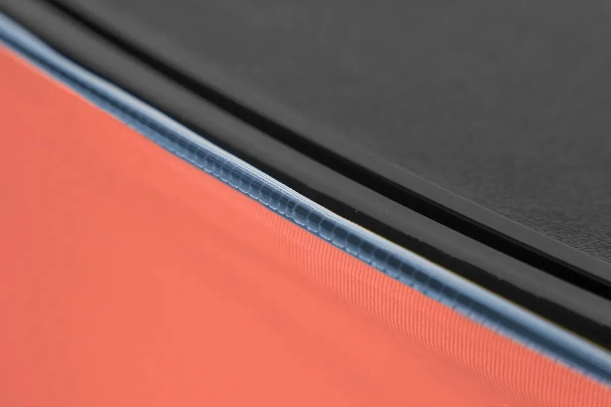 Dettaglio di una superficie digitale, probabilmente lo schermo di un dispositivo elettronico, con una cornice blu sopra un fondo arancione.