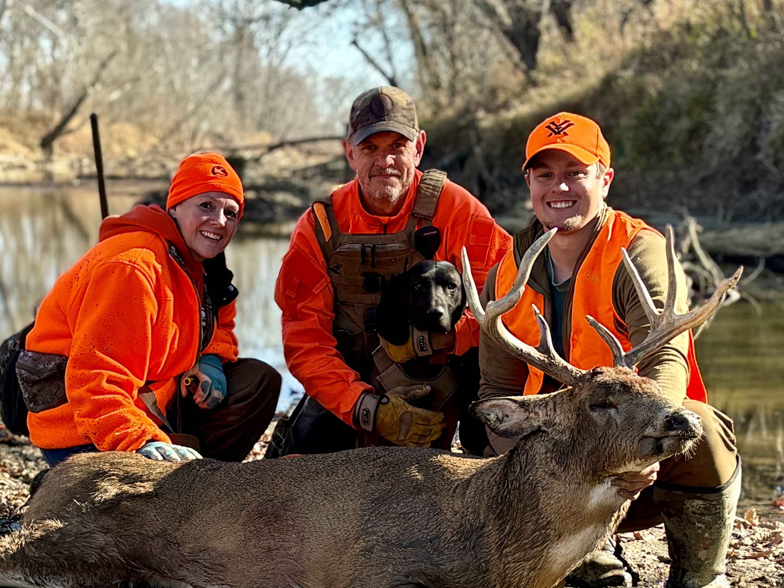 tracking dog and hunter with recovered white-tailed deer in river