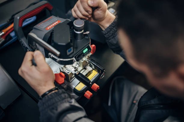 Person working on a circuit board with specialized tools, wearing a dark jacket, in a workshop setting. part of a Complete Fire and Security System in Southampton, Hampshire.