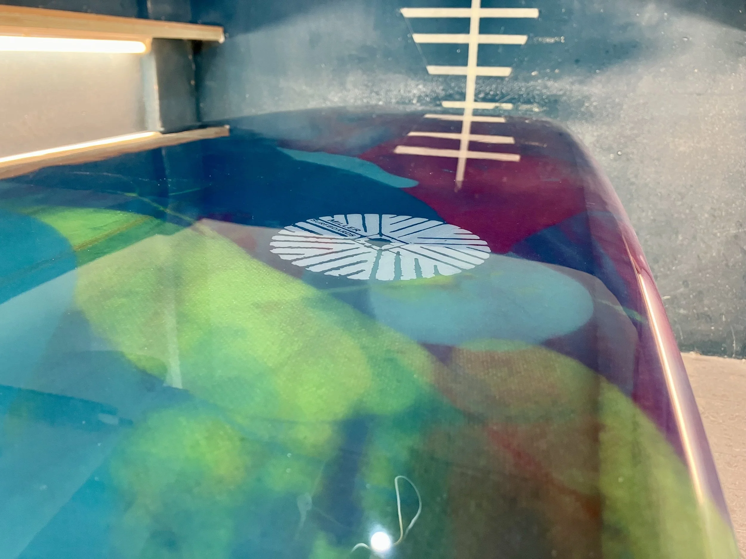 shine abstract resin tint surfboard longboard on a stand in a shaping bay