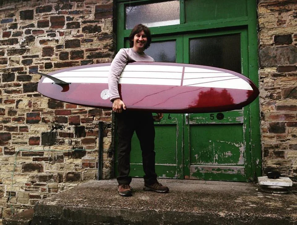 ox blood red resin tint surfboard with cream resin panel artwork