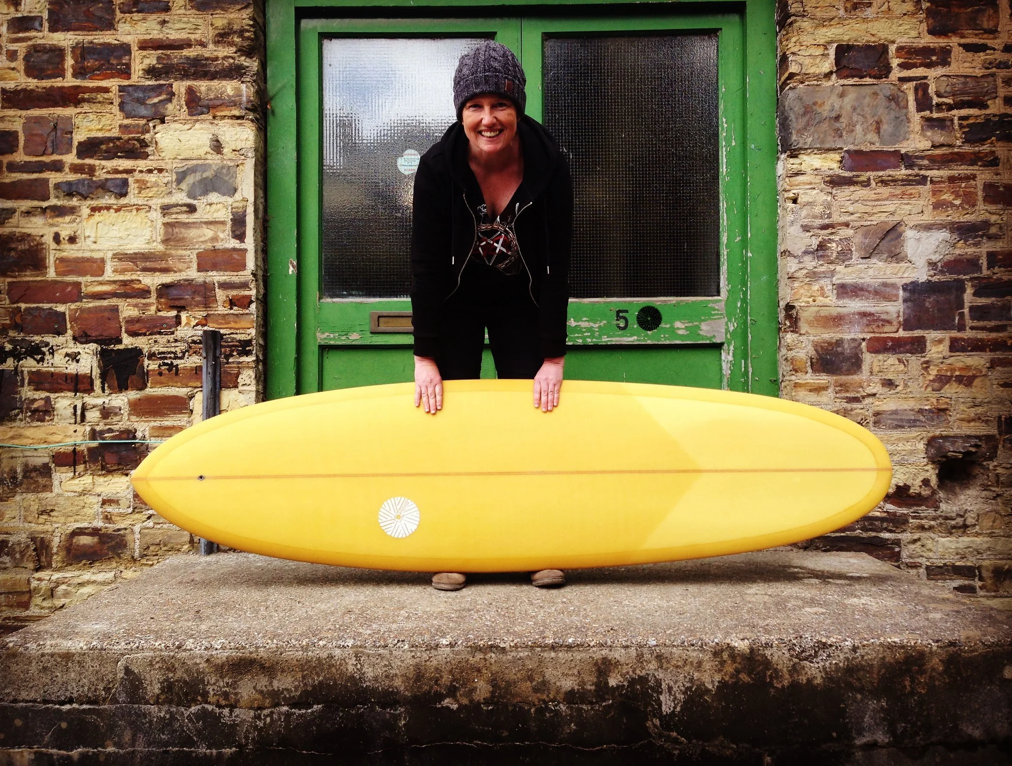 Ellie and single fin mid length surfboard with yellow resin tint
