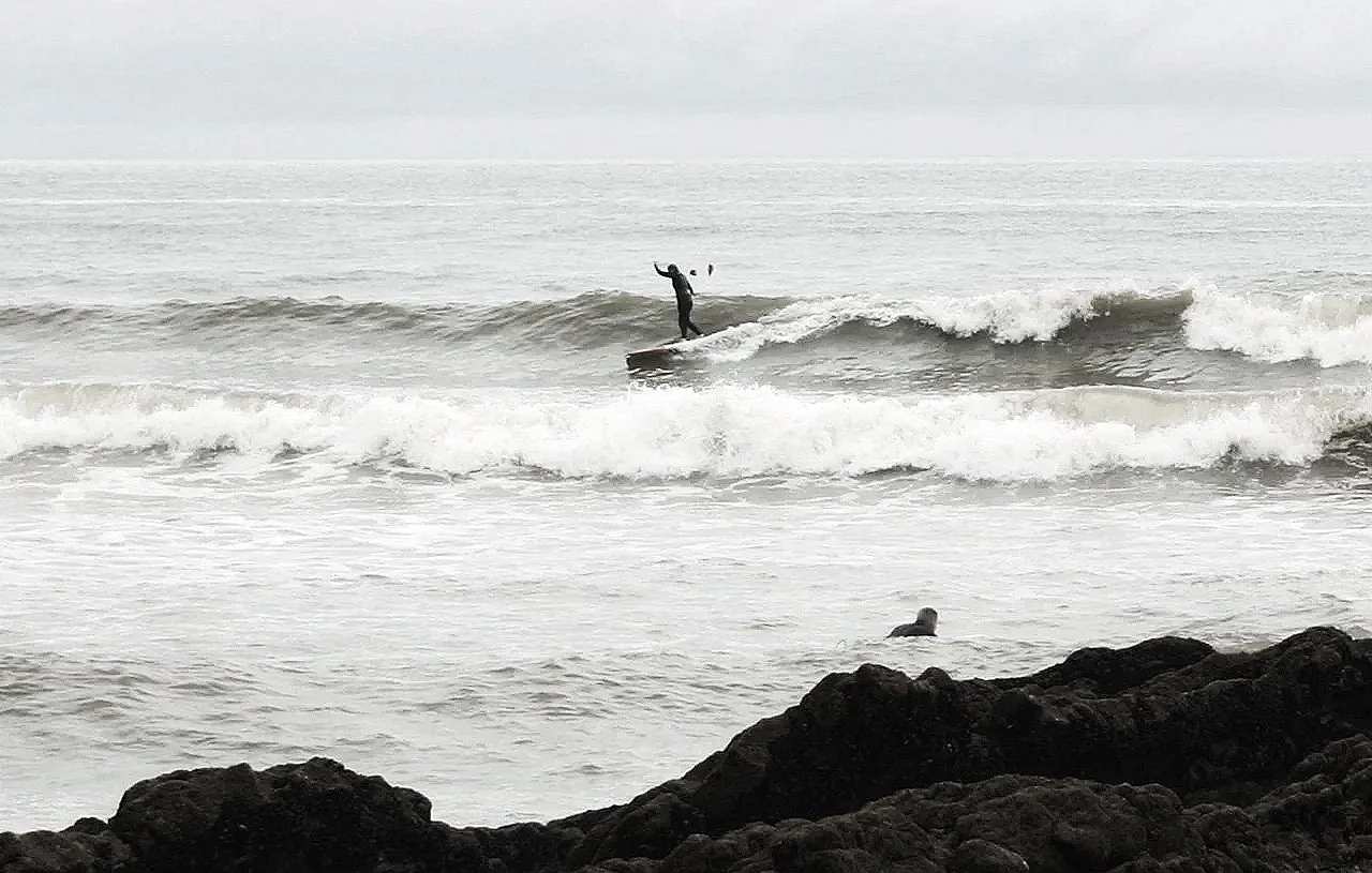female surfer cross-stepping to the nose of a longboard in crumbly waves