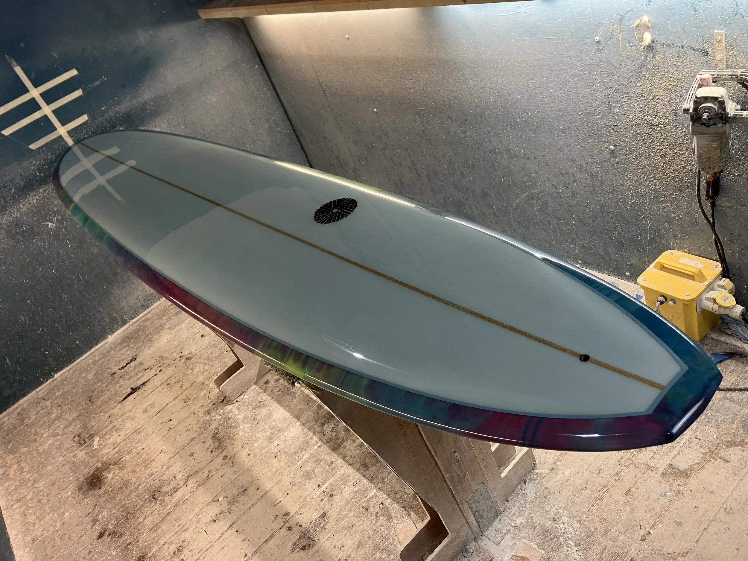 shine abstract resin tint surfboard longboard on a stand in a shaping bay