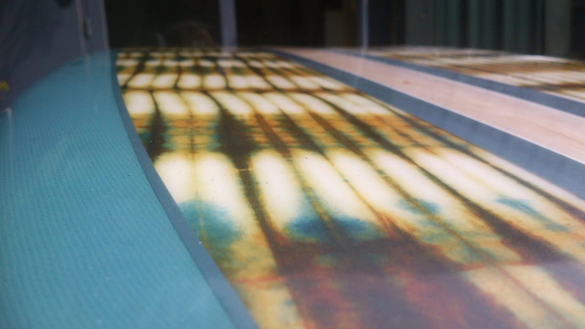 African fabric inlay on longboard surfboard with pin-lines in resin