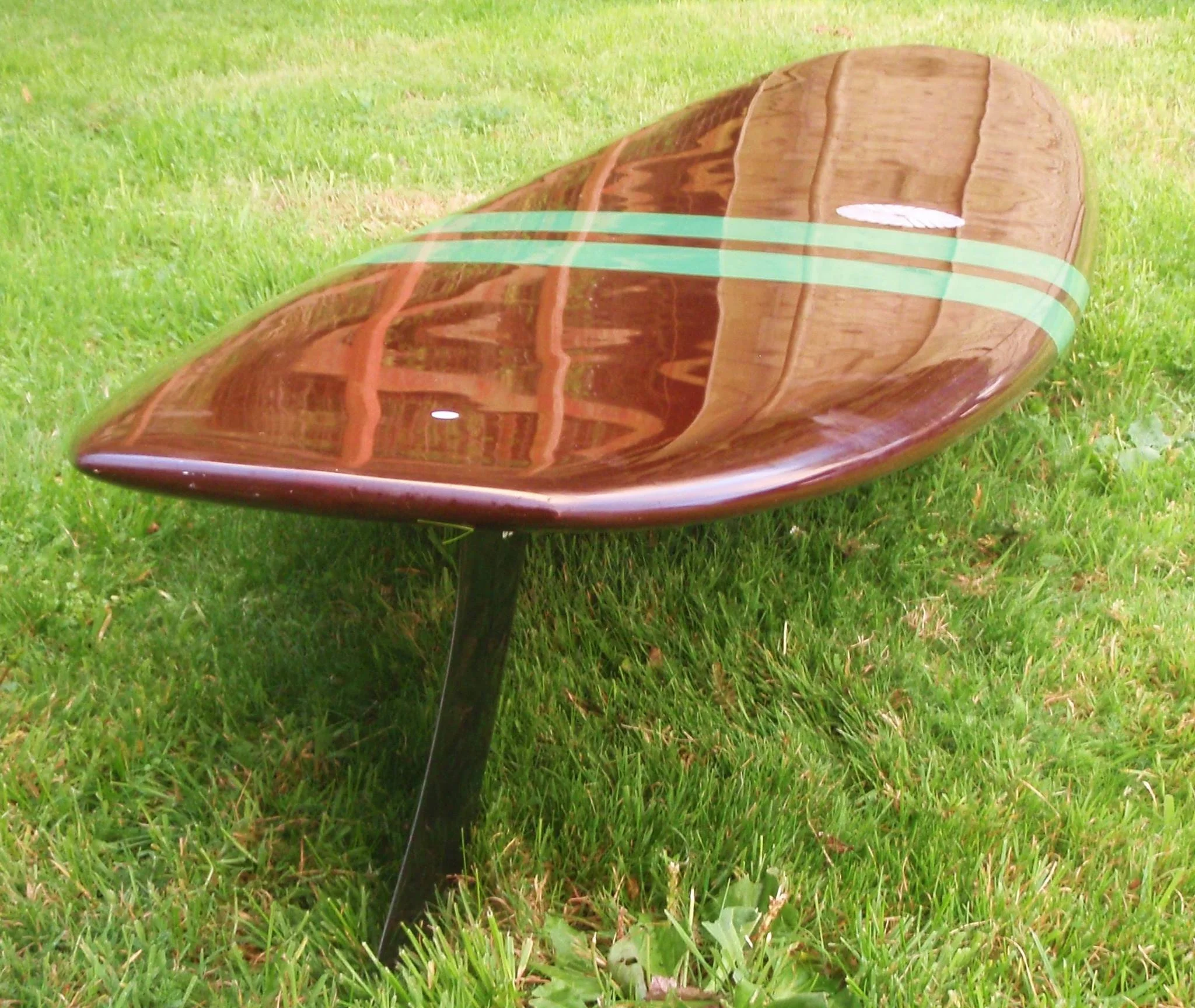 single fin noserider surfboard with gloss finish and red resin tint