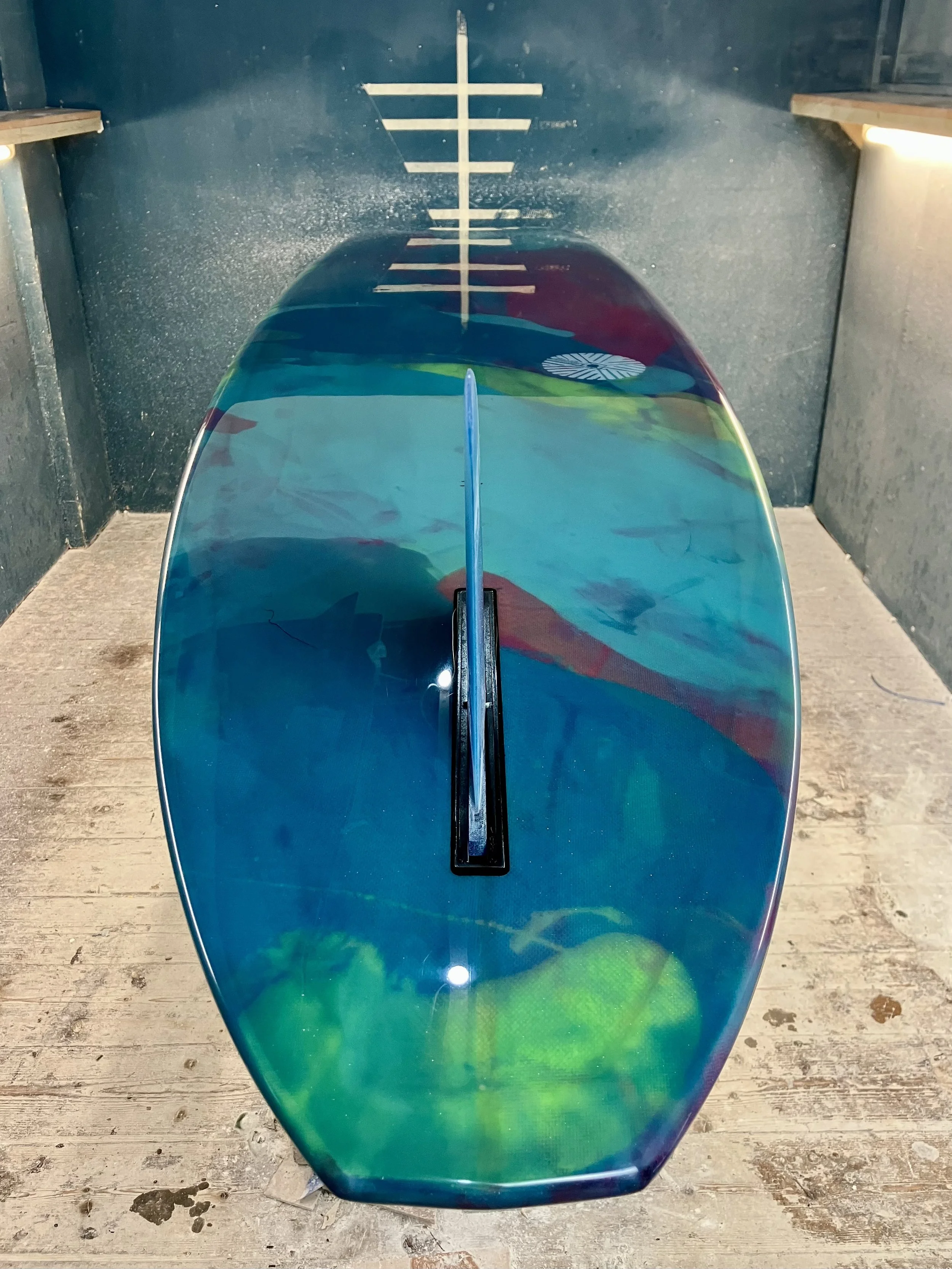 shine abstract resin tint surfboard longboard on a stand in a shaping bay