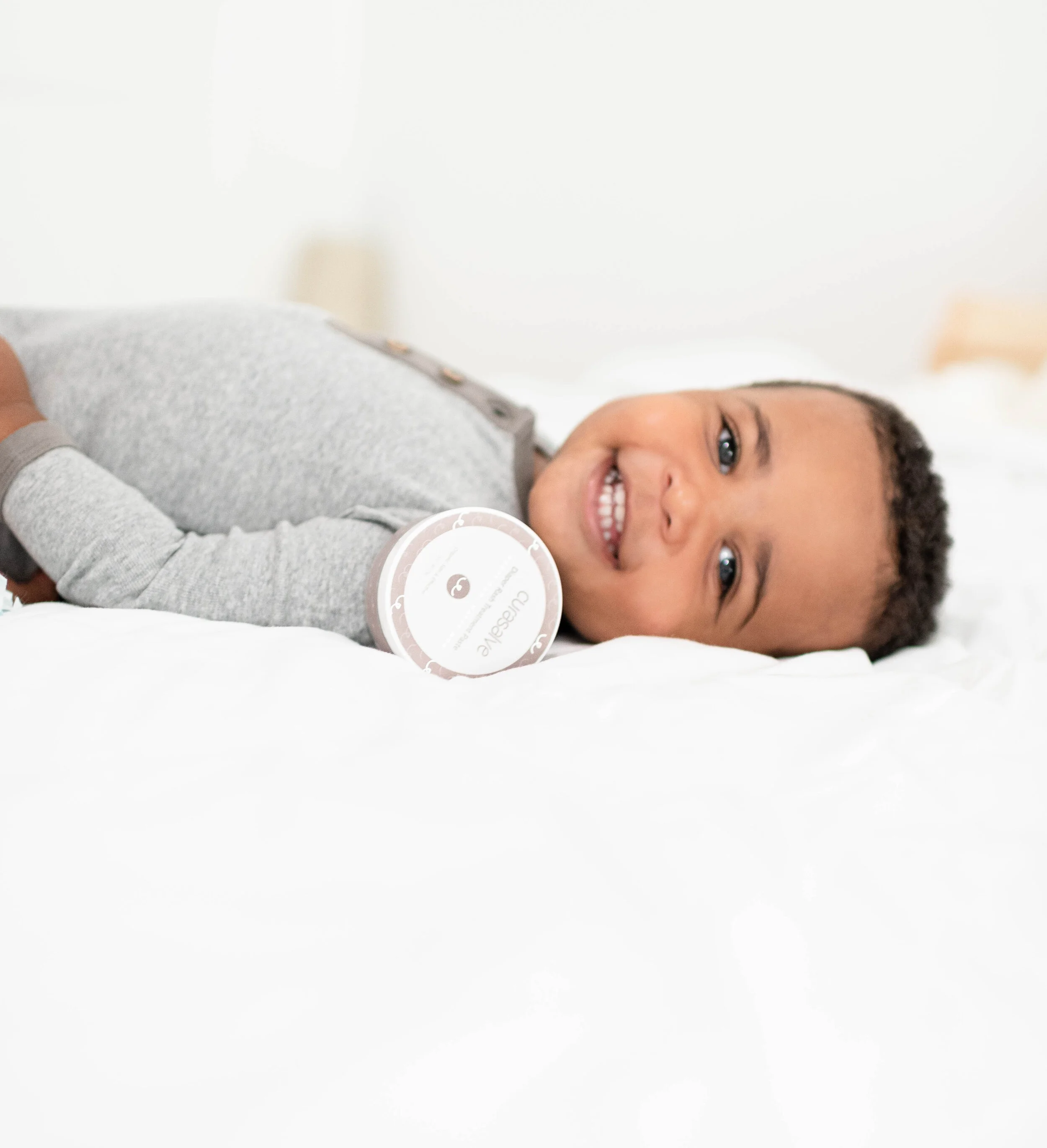 Smiling young boy lying on a bed.
