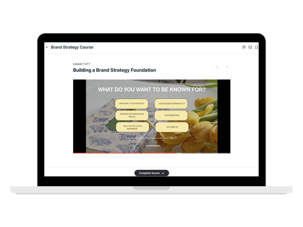 Laptop screen displaying an online course titled 'Brand Strategy Course' with a lesson on building a brand strategy foundation. The slide asks, 'What do you want to be known for?' with options including high quality deliverables, creating stunning brand visuals, top tier client experience, magnetic personality, messaging, and not sure yet.