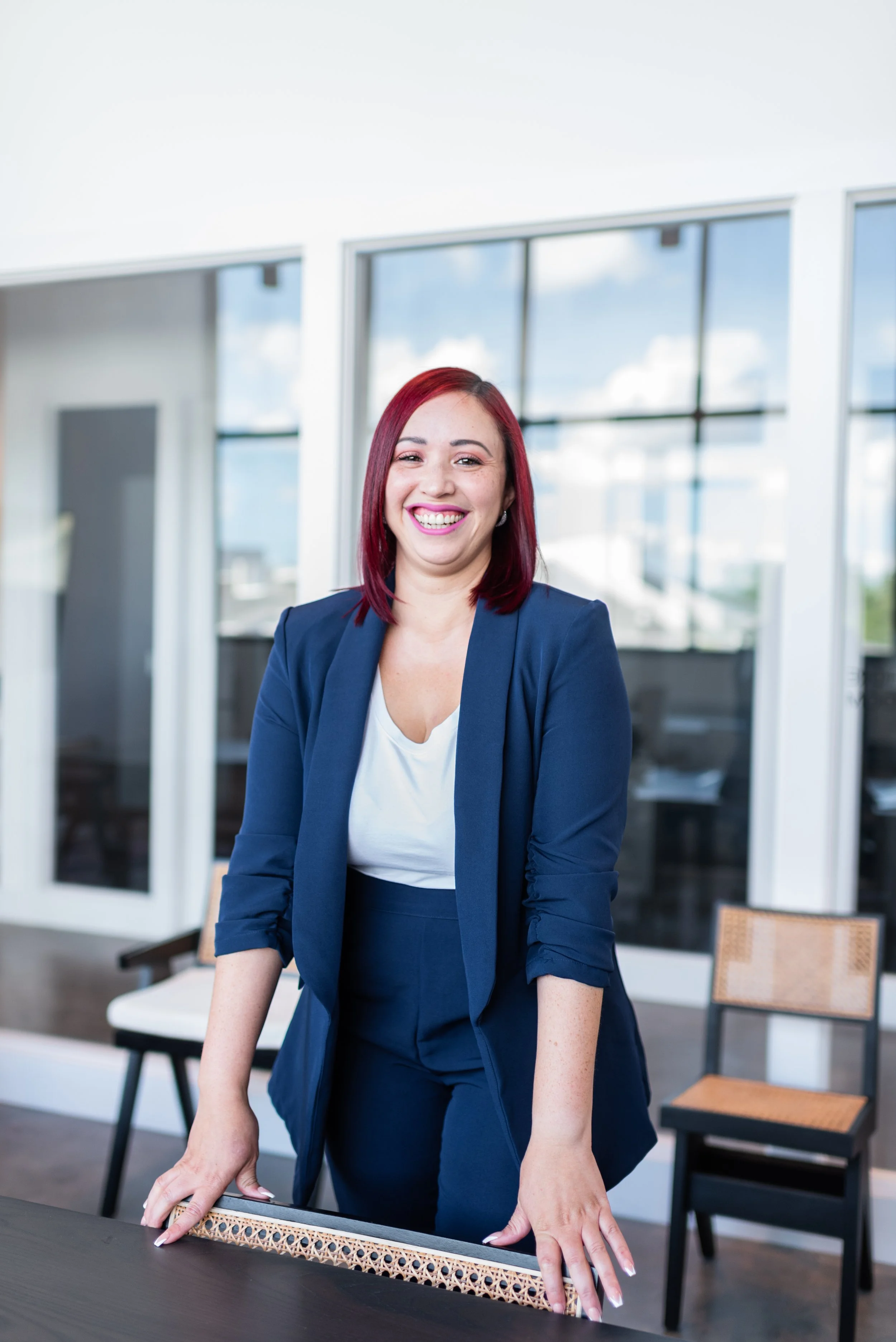 Businesswoman with red hair smiling in modern office