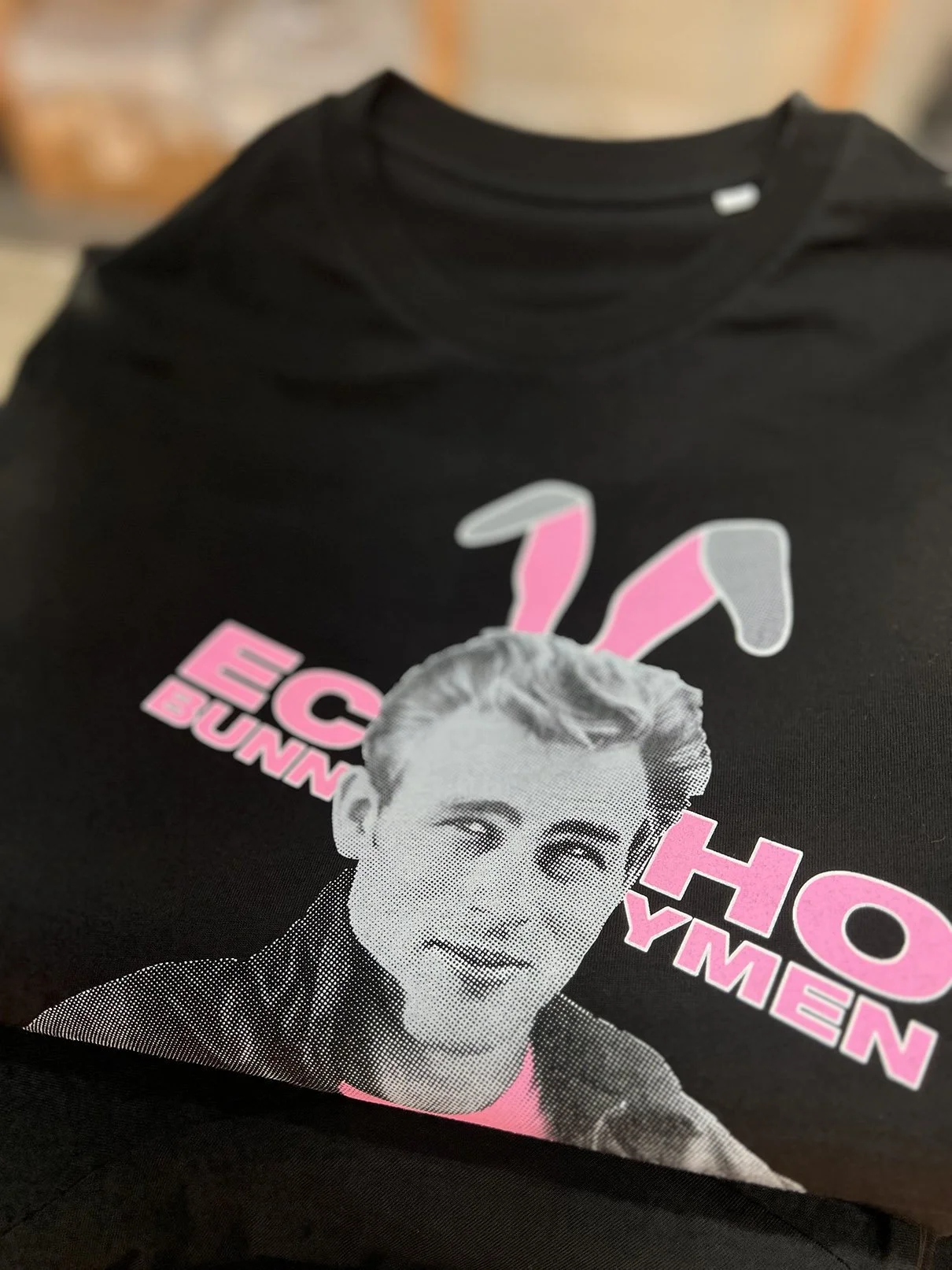 Black T-shirt with a graphic of a James Dean with pink bunny ears, and pink text for Echo and The Bunnymen. Ethically made from organic cotton and printed in huddersfield by Huddersfield Screenprinting