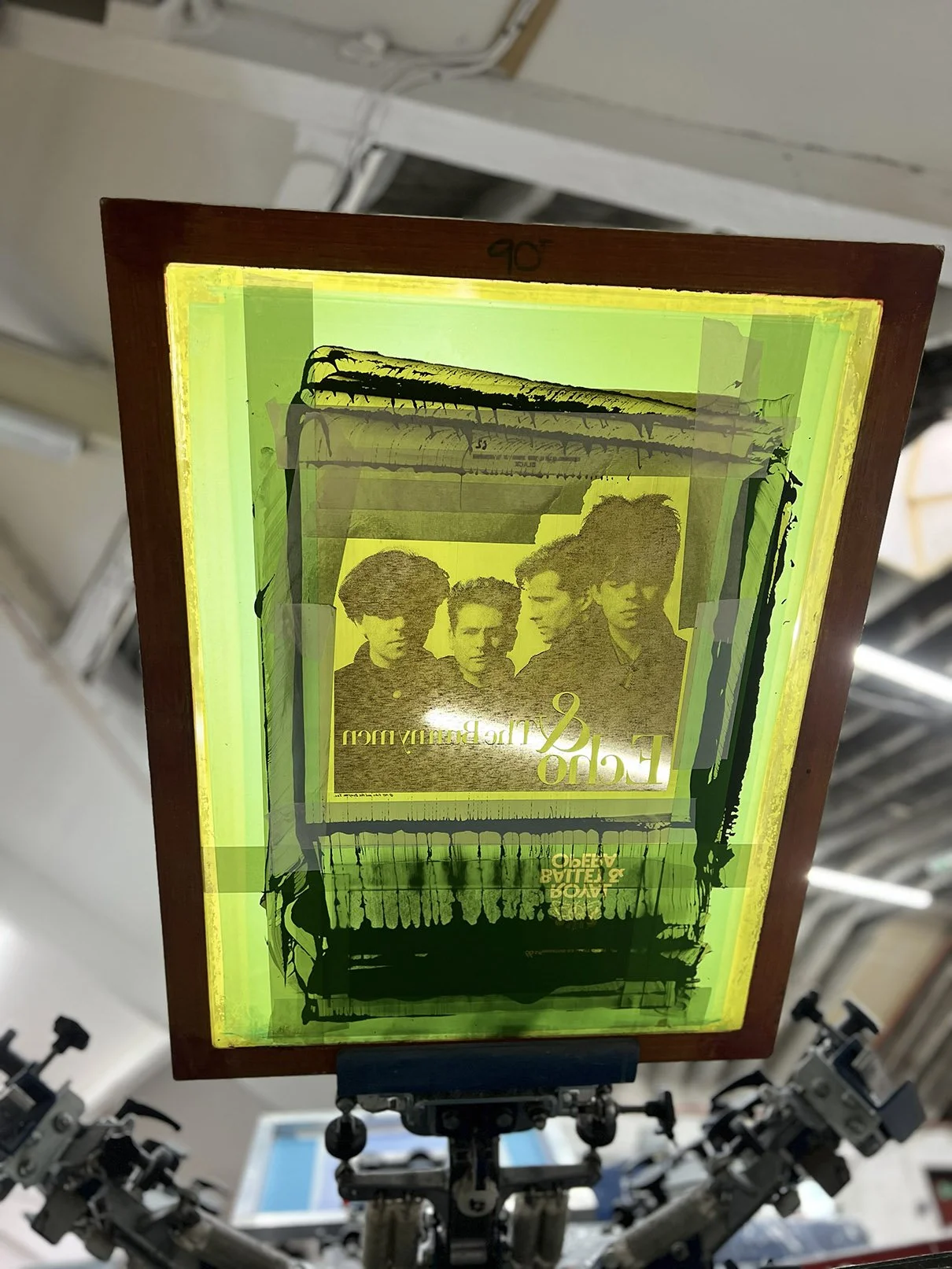 A layered, abstract print featuring a vintage photo of four women with short hair, with text 'FEMME & THE BURNING MEN' upside down, on a bright yellow-green background.