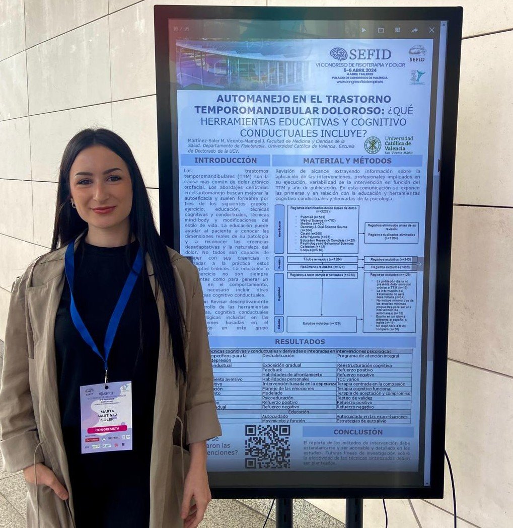 Mujer con gafete posando junto a un cartel científico en una conferencia.