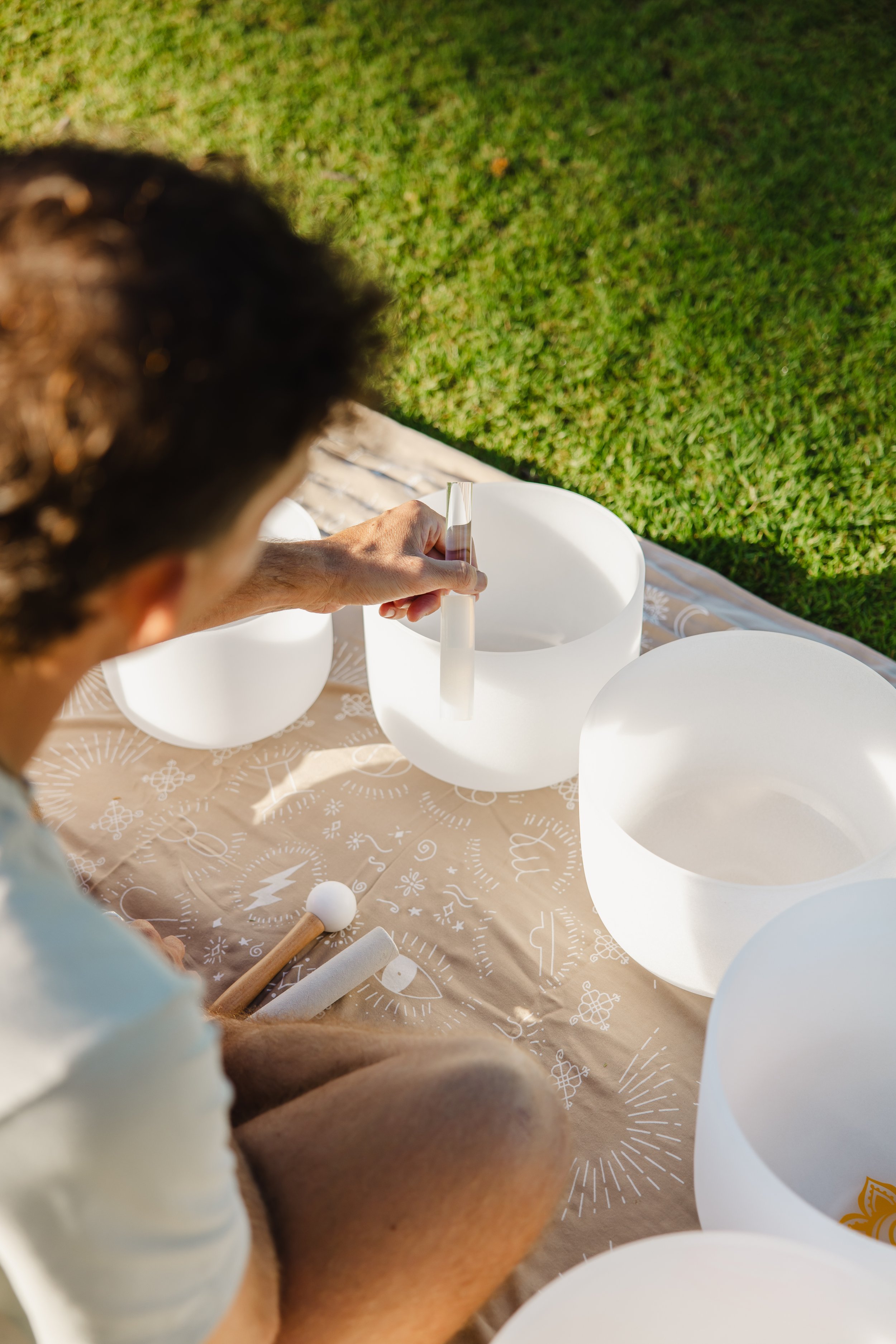 Male playing a crystal sound bowl