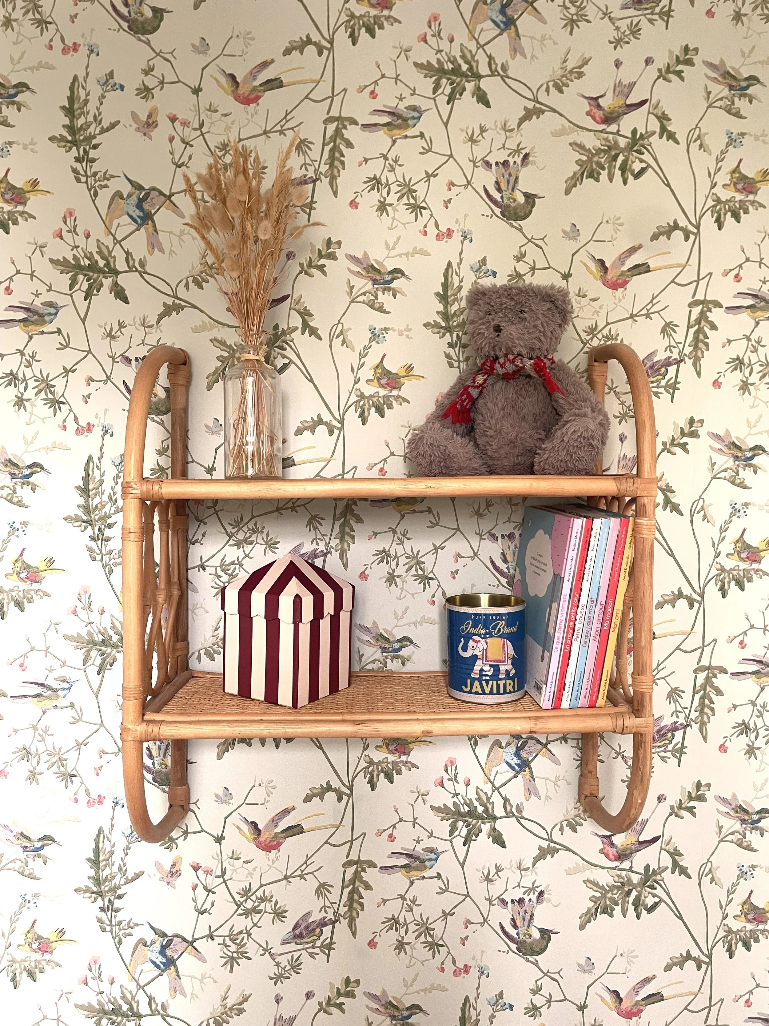 Etagères en rotin sur papier peint à motifs floraux et animaliers