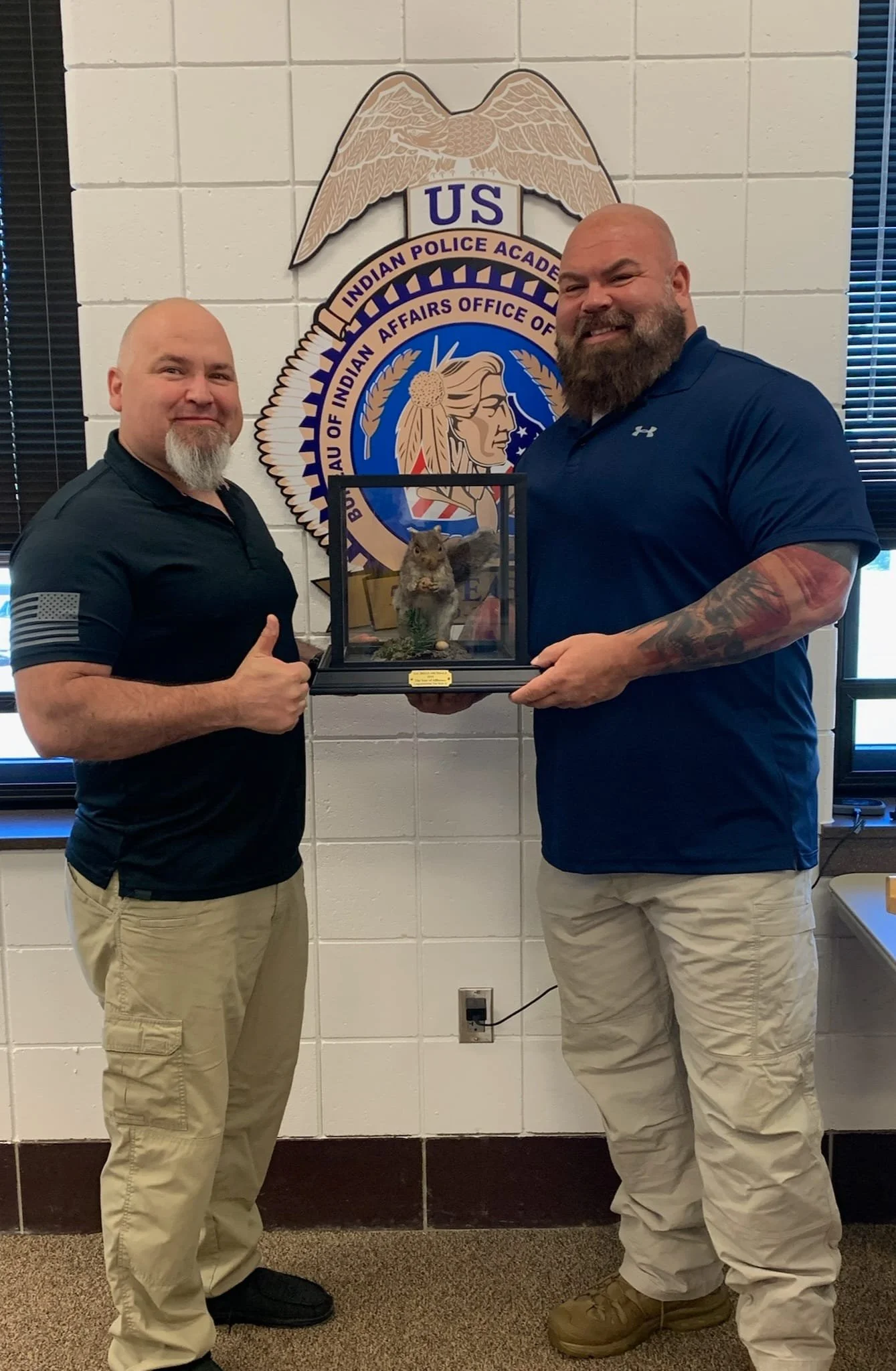 Jerin Falcon presenting SAC Brian Archdale with a stuffed squirrel as the Year of Affluence Award after Brian succeeded him as Special Agent in Charge of District VII.