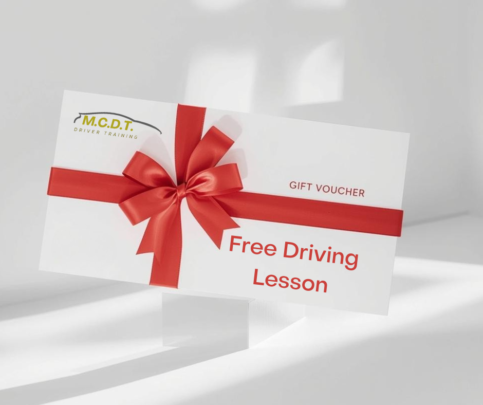 Gift voucher with a red ribbon and bow, advertising free driving lessons, from M.C.D.T. Driver Training.