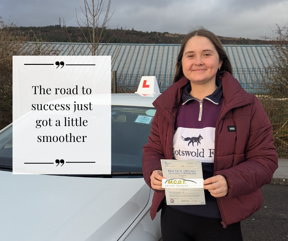 A young woman standing next to a white driving school car, holding a driving test certificate, smiling. The car has an 'L' learner sign on top, and she is wearing a maroon jacket and a purple hoodie with a dog logo and the words 'Motswold F'. A quote on the image says, 'The road to success just got a little smoother.'