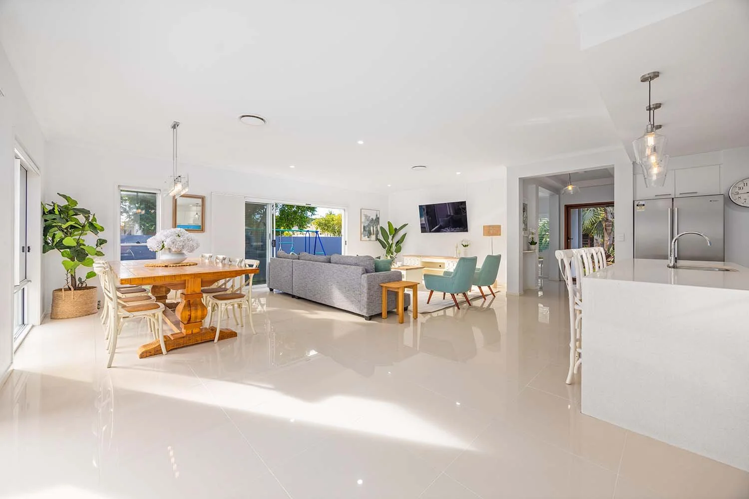 Bright, modern open-plan living and dining area with Stainless steel security window and door screens installed in Gold Coast home.