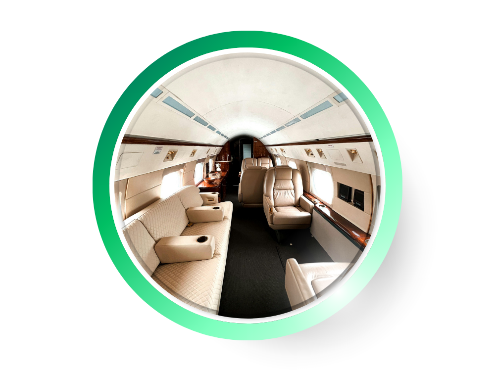 Intérieur luxueux d'un avion privé avec sièges en cuir beige, fenêtres ovales, et détails en bois