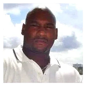 A man with dark skin and short hair taking a selfie outdoors with a cloudy sky in the background.