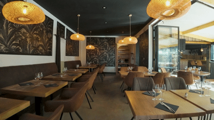 Intérieur d'un restaurant cosy avec tables, chaises en cuir, et décor floral
